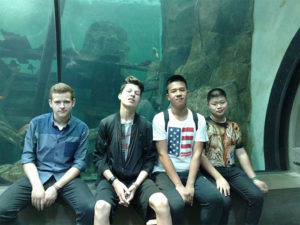 Jakob, an exchange student from Germany, in front of a fish tank with friends