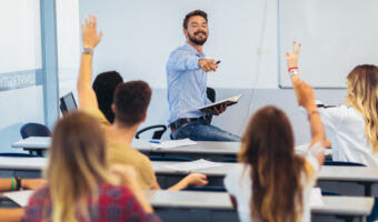 Group of students raising hands in class on lecture