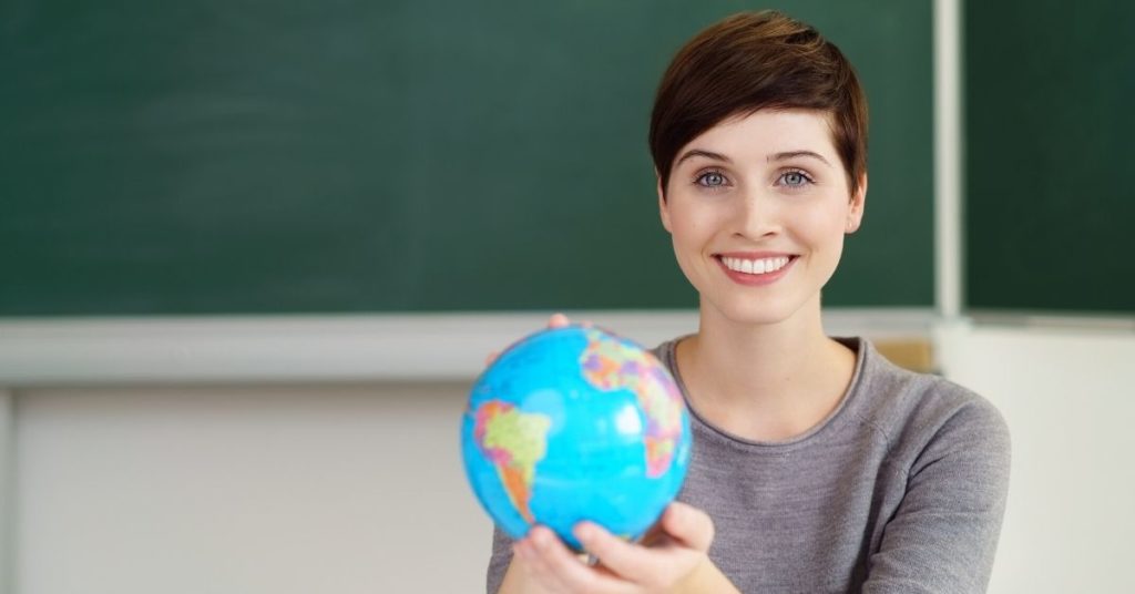 Teacher with globe in classroom
