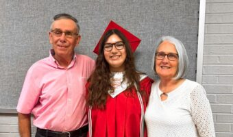 exchange student from brazil in graduation cap and gown with host family in kentucky