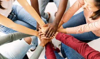 young friends people putting their hands together showing community, support, cooperation, unity and teamwork