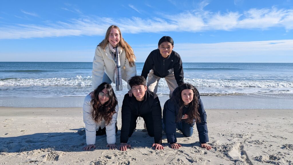 exchange students making a pyramid on the beach in south carolina